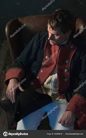Homme L'empire Historique Avec Chapeau Sur Genou Assis Dans Une image libre  de droit par ysbrand © #203658618
