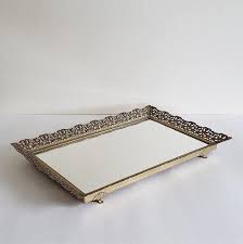 The braid serving tray's rich acacia body is amplified by intricately woven chrome handles, making it a decorator statement perfect for dinner parties, small gatherings and more. Vintage Filigree Frame Vanity Mirror Large Rectangular Tray Brass Frame Footed Ornate Antique Style Serving Tray 1960s Ormolu Decor Brass Frame Antique Style Vintage Mirror