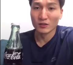 Asian Guy Flicks Coca Cola Bottle Open
