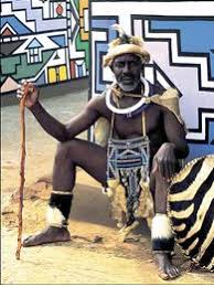 Traditional ndebele woman with ndebele murals, kwandebele area, south africa traditional ndebele woman with ndebele murals a ndebele woman wears traditional tribal attire. Ndebele Traditional Dress Vuk Uzenzele