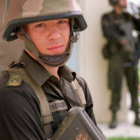 An Austrian soldier armed with a Steyr AUG rifle sits in his position  during 360 degree security measures, while receiving training