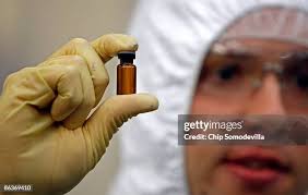 Manufacturing Engineer Nate Forrest holds a small glass vial like... News  Photo