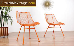 Elegant spiraling design on table top and seats and decoratively scrolled chairs' backrests add class and chic to this furniture. Pair Of Mid Century Modern Russell Woodard Outdoor Patio Chairs