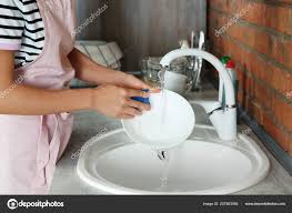 woman washing dishes kitchen sink