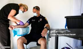 Medical assistant Tammy Loring, left, draws a blood sample