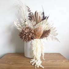 Neutral colors such as gray, beige, taupe, ivory, and charcoal are ideal because it will give a sophisticated and fresh look to any dried floral arrangement. Neutral Dried Flower Arrangement In White Pot Dried Flower Arrangements Dried Flower Arrangement Dried Flowers