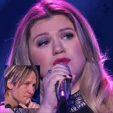 Kelly Clarkson begins singing her emotional song "Piece by Piece" but  struggles to make it to the end. With lines like "| will never leave her  like you left me and she