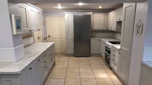 In this kitchen, light grey cabinets are complemented by a large black island countertop. Kitchen Remodelling Makeover Renovation Refurbishment Cabinet Unit Door