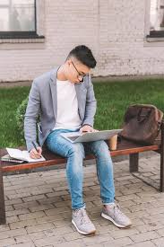 Für selbstständige und freiberufler ist es in der regel nicht ganz einfach, von der bank ein darlehen zu bekommen. Asiatischer Freiberufler Schreibt Im Planer Wahrend Er Auf Dem Smartphone Spricht Und Auf Der Bank Am Laptop Arbeitet Lizenzfreies Foto Und Stockbild
