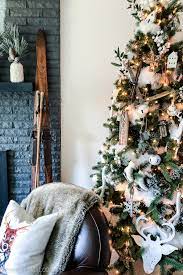 Made of rustic white wood, this stunning furniture piece offers distressed black spots and scrapes, a metal bar with a sliding door, two empty compartments on the left, and three drawers on the right side with an empty compartment at the top. White Scandi Farmhouse Christmas Tree Decor The Happy Housie