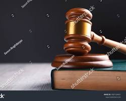 Image of gavel, a stack of legal documents, and a confusedlooking person