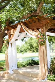 Burlap Draping With Country Pink And Green Flowers Over A Wooden Pergola Photographer Jeremy Burlap Wedding Decorations Wedding Arch Rustic Wedding Pergola