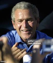 US President George W. Bush holds Kaylyn, daughter of Angel Howell... News  Photo