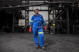 Mining safety helmet, gloves, and a clipboard with safety documents.