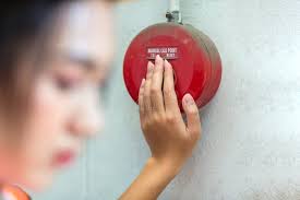 Foreman or Worker Pushing Fire Alarm