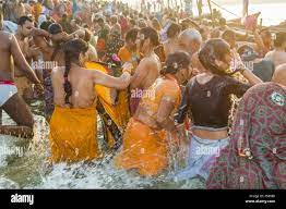 People taking bath at the Sangam, the confluence of the rivers Ganges,  Yamuna and Saraswati, at Kumbha Mela Stock Photo 