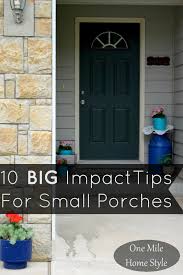 Cozy front porch of peach colored house with arches and white columns and balistrade, french windows, potted plant and furniture for relaxing. 10 Tips For Giving Your Small Front Porch A Big Impact