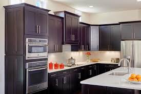 This Light And Bright Kitchen Features Dark Brown Wooden Shaker Cabinets Paired Wi Backsplash For White Cabinets Building Kitchen Cabinets Beadboard Backsplash