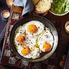Egg curry over rice on a blue and white plate. 12 Genius Ways To Use Up Eggs Delicious Magazine