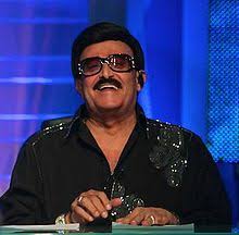 سمير غانم اسم فني يحمل رصيدا ضخما من الأعمال المتنوعة بين السينما والدراما والمسرح وحتى الفوازير، إلى جانب رصيده الإنساني. Samir Ghanem Wikipedia