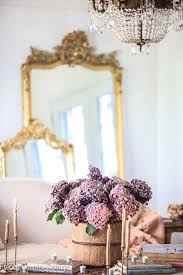 It includes cozy seats and a wooden coffee table that blends in with the light hardwood flooring. Autumn In The Living Room French Country Cottage