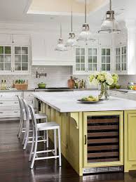 It includes wooden cabinetry and a breakfast nook completed with a metal table and a curved leather seat. Kitchen Island Wine Fridge Transitional Kitchen Bhg
