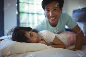 Padre E Hija Se Divierten En La Cama En La Habitación De La Casa Fotos,  retratos, imágenes y fotografía de archivo libres de derecho. Image 79811185