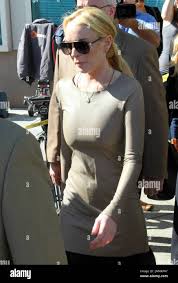 Wearing a simple tan dress, and with her mother following behind, Lindsay  Lohan leaves the courthouse after a hearing to potentially resolve the  alleged theft of a $2,500 necklace. Lindsay pleaded not