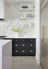 Stacked Marble Floating Shelves Are Mounted On A White Marble Slab Backsplash Beside A Marble Kitchen Remodel Trends Black Kitchen Cabinets Home Decor Kitchen