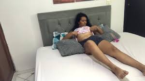 Chica latina quitándose la ropa antes de ducharse en casa