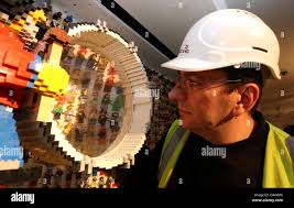 LEGOLAND Windsor model maker Neville Smith puts the finishing touches to a  wall made up of over 6000 Lego figures. The wall is situated in the  Reception area of the resort's new