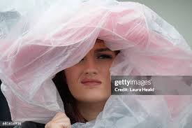 Closeup of female fan wearing fancy hat covered with plastic during... News  Photo