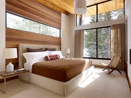 A bedroom by the windows opposite a mirrored cabinet. 20 Contemporary Bedrooms With A Beautiful Outdoor View From Glass Windows Home Design Lover