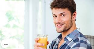 A portrait of fit mixed race man resting after doing exercise at home, drinking juice. Boost Your Fertility With Prenatal Vitamins For Men