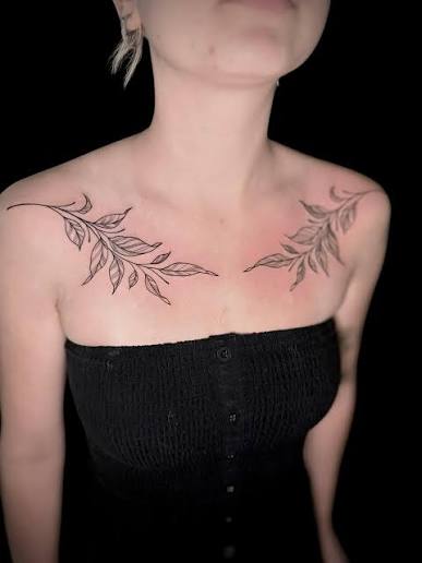 These fine-line leafy designs flow gracefully across the collarbones — a timeless blend of femininity, balance, and natural strength. Placed perfectly to enhance the body's natural curves, this symmetrical style frames the