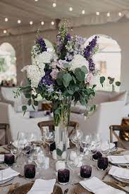 Seating charts act as crowd control, disseminating key information to guests about where their reception home base will be all evening, so you don't have to worry about everyone knowing where to go. Gorgeous Purple Floral Arrangement On Table At Wedding Reception By Leah Flores Reception Wedding