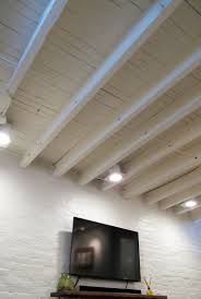 Cozy Chic Basement Reno With Exposed Painted Joists Wood Tile Floors Basement Lighting Basement Makeover Diy Basement