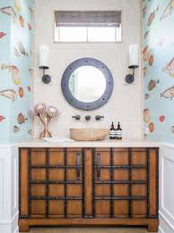 A beautiful coastal bathroom clad with light blue hex tiles, a large floating vanity, touches of black and brass Coastal Bathroom Ideas Hgtv