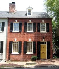 Tuscany doors, wooden door, pienza doors and balcony, italy travel, black shutters, red flowers, textured house antique shutters doors, louvered panel doors, interior shutters, architectural salvage literary fairy house with red roof, black shutters and vintage floral door with button. Brick House With Yellow Shutters Novocom Top