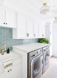 Light brown cabinets hang over stacked white porcelain tiles and a marble look countertop that boast a potted plant and books. Salt And Sand Unseen Images From The Latest Issue Of Rue Rue
