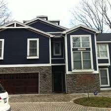 Also i do like the white trim but wonder about it staying clean over time. Blue House With Dry Stacked Stone And Dark Wood Exterior House Colors House Exterior House Paint Exterior