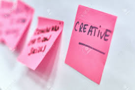 creative written on pink paper stickers attached to a flip chart