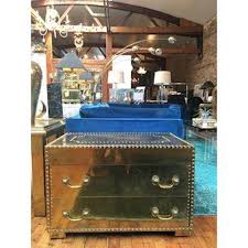Defined by its nailhead trim and understated design, this trunk coffee table is a handsome addition to your favorite aesthetic. Brass Two Drawer Trunk Coffee Table With Nailhead Trim At 1stdibs