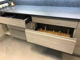 A grey gloss kitchen with contrasting quartz glass effect splashback. Ex Display Wood Grain Grey Gloss Kitchen The Used Kitchen Company