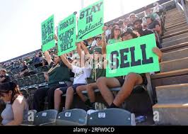 From left to right, Kamryn Miller, Kayson Miller, Marcus Telles and Manuel  Telles hold up signs in the first inning of a baseball game between the  Oakland Athletics and the San Francisco