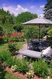 Gorgeous Summer Backyard Landscaping And View Of Flower Garden Scene With Patio Furniture Umbrella Table Set Backyard Garden Layout Backyard Garden Backyard