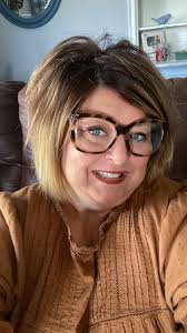 What hairstyle suits a 53-year-old woman with a round face to look younger?