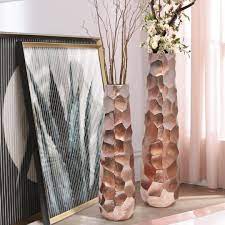 The vase features a fluted design, with slender ridges creating a textured pattern. Tapered Metal Floor Vase