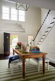 The entryway décor could combine old values and new sensibilities at once. Farmhouse Table With Green Striped Rug Cottage Entrance Foyer