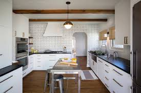 An airy kitchen with dove grey cabinets, a white subway tile backsplash and wooden cuntertops looks cool and bold. Black And White Kitchen With Mosaic Tile Backsplash Modern Kitchen